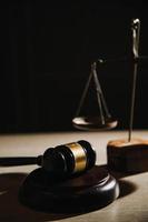 Justice and law concept.Male judge in a courtroom with the gavel, working with, computer and docking keyboard, eyeglasses, on table in morning light photo