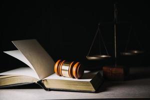 Justice and law concept.Male judge in a courtroom with the gavel, working with, computer and docking keyboard, eyeglasses, on table in morning light photo