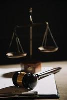 Justice and law concept.Male judge in a courtroom with the gavel, working with, computer and docking keyboard, eyeglasses, on table in morning light photo