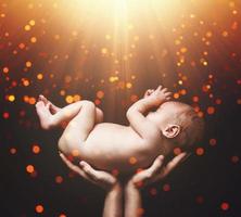 lindo bebé recién nacido en manos de la madre foto