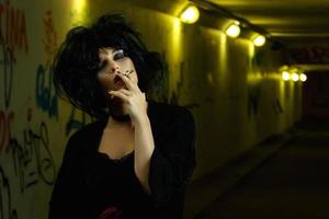 Freaky woman with black hair smoking a cigarette photo