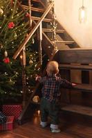Little boy wearing checkered shirt at home during Christmas eve.