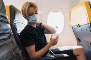 Woman wearing prevention mask during a flight inside an airplane photo