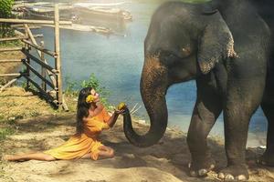 mujer con hermoso vestido naranja y poderoso elefante foto