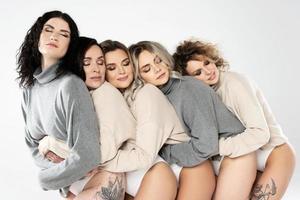 Group of different women wearing turtleneck jumpers on gray background photo