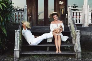 Young lovely couple sitting on the stairs of the porch photo