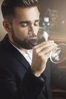 guapo hombre barbudo con una copa de vino tinto foto