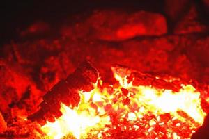 Closeup shot of campfire brightly burning at night radiating heat. photo