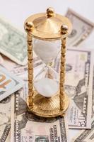 Hourglass and US dollar banknotes. Concept of investment and inflation. photo