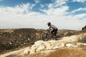 Professional bike rider during downhill ride on his bicycle photo