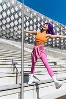bailarina despreocupada con ropa deportiva colorida divirtiéndose en el poste