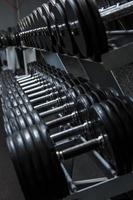 Different black dumbbells in the modern gym photo