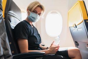 Woman wearing prevention mask during a flight inside an airplane photo