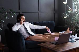 Lazy businessman without pants working from home photo