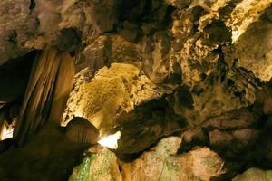 Natural dark underground cave with strangely shaped stalactites. photo