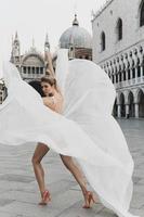 Woman wearing beautiful white dress at the Piazza San Marco photo