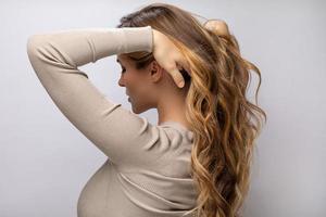 mujer joven mostrando su hermoso cabello después de teñir y peinar foto