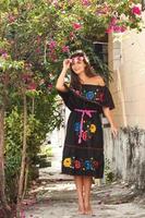 Young beautiful woman wearing traditional mexican dress on the city street photo