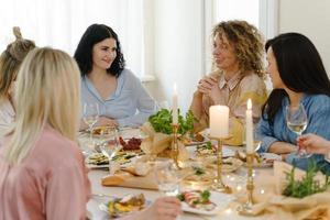 Young women friends laughing at the festive dinner. photo