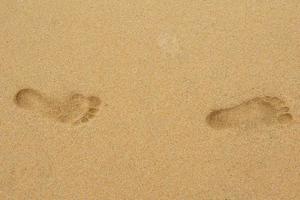 Two foot prints on the sandy sand photo