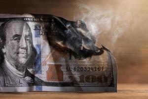 Closeup shot of burnt remainings of a one hundred dollar bill damaged in a fire photo