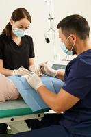 Doctor and nurse during dermatological surgery photo