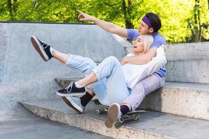 Stylish teenager couple in love during their date in a skate park photo