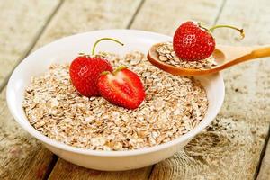 copos de avena y fresa en la mesa de madera foto