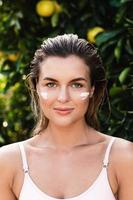 Beautiful woman with moisturizing cream under her eyes photo