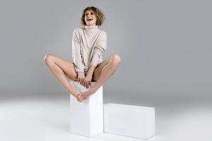 Young and sexy woman with curly blond hair posing  in studio photo