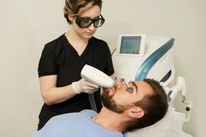 Young man during IPL treatment in a cosmetology medical clinic photo