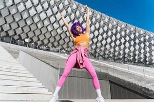 bailarina activa despreocupada con ropa deportiva colorida divirtiéndose en la calle