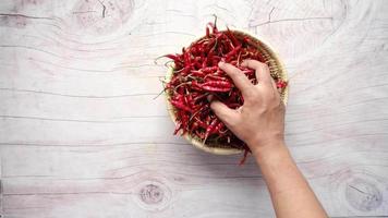 Hand picks dried peppers in a bowl on the table video