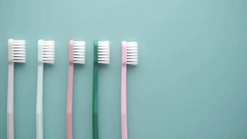 Colorful toothbrushes on light green background video