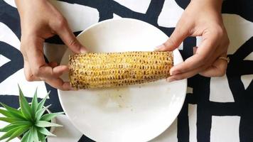 Corn on the cob ready to eat on a plate on the table video