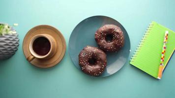 donuts en plato con café y cuaderno