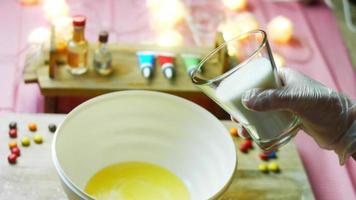 Mix the cake ingredients with the mixer. The baby is sitting in a chair and enjoying himself video