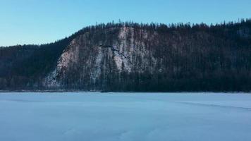 de stralen van de instelling zon verlichten de berg, time-lapse. chulman rivier- in winter in neryungri. zuiden jakutia, Rusland video