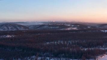 los rayos del sol poniente iluminan la ciudad, el lapso de tiempo. invierno en neryungri. yakutia del sur, rusia
