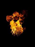 las llamas reales y calientes arden sobre un fondo negro. foto