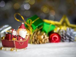 Happy Santa Claus with gifts box on the snow sled the background is Christmas decor.Santa Claus and Christmas decor on the snow. Merry Christmas and happy new year concept photo