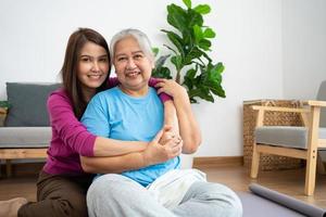 cuidadoso cuidador asiático o enfermera cuidando al paciente en un hogar. concepto de jubilación feliz con el cuidado de un cuidador y ahorros y seguro de salud para personas mayores, una familia feliz foto