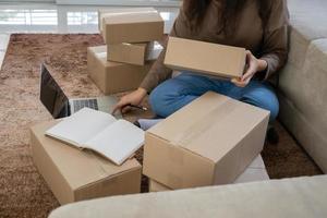 Happy young asian entrepreneurs are arranging boxes for delivering products to customers. Small business owner and success in online business concepts. photo