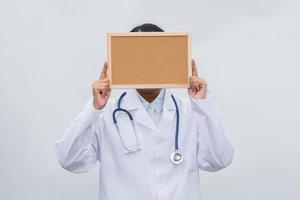 profession doctor in white coat over white isolated background with white blank board. Concept of healthcare, science and medicine concept photo