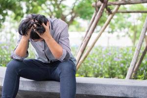 Negative emotion facial expression feelings. Stressed Asian businessman in depression with hands-on forehead because of work problems And was fired. photo