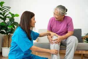 physiotherapist doctor or caregiver helping senior older woman stretching his hamstring and doing thigh or leg rehabilitation in exercise room, Osteoarthritis of the Knee and caregiver concept photo