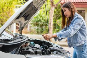 Asian woman and using smartphones to send engine pictures and send to assistance after a car breakdown on street. Concept of vehicle engine problem or accident, emergency help from Professional photo
