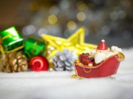 Happy Santa Claus with gifts box on the snow sled the background is Christmas decor.Santa Claus and Christmas decor on the snow. Merry Christmas and happy new year concept photo