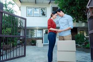 Man comforting his wife and woman hugging her husband and cry in front of the house and full of cardboard boxes during the transport in move out day, moving home concept photo