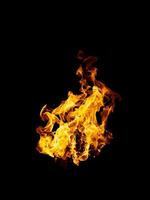 las llamas reales y calientes arden sobre un fondo negro. foto